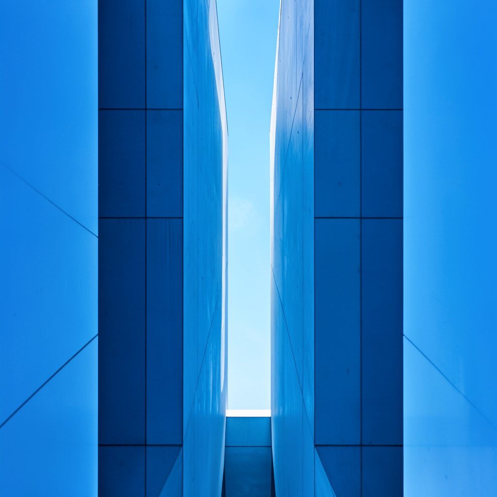 Abstract blue and gold conference-themed graphic with clean geometric forms